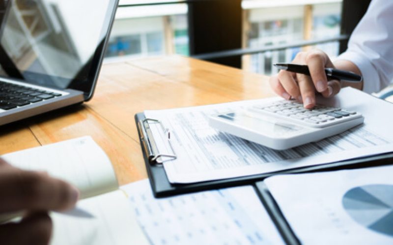 person-using-calculator-over-financial-documents